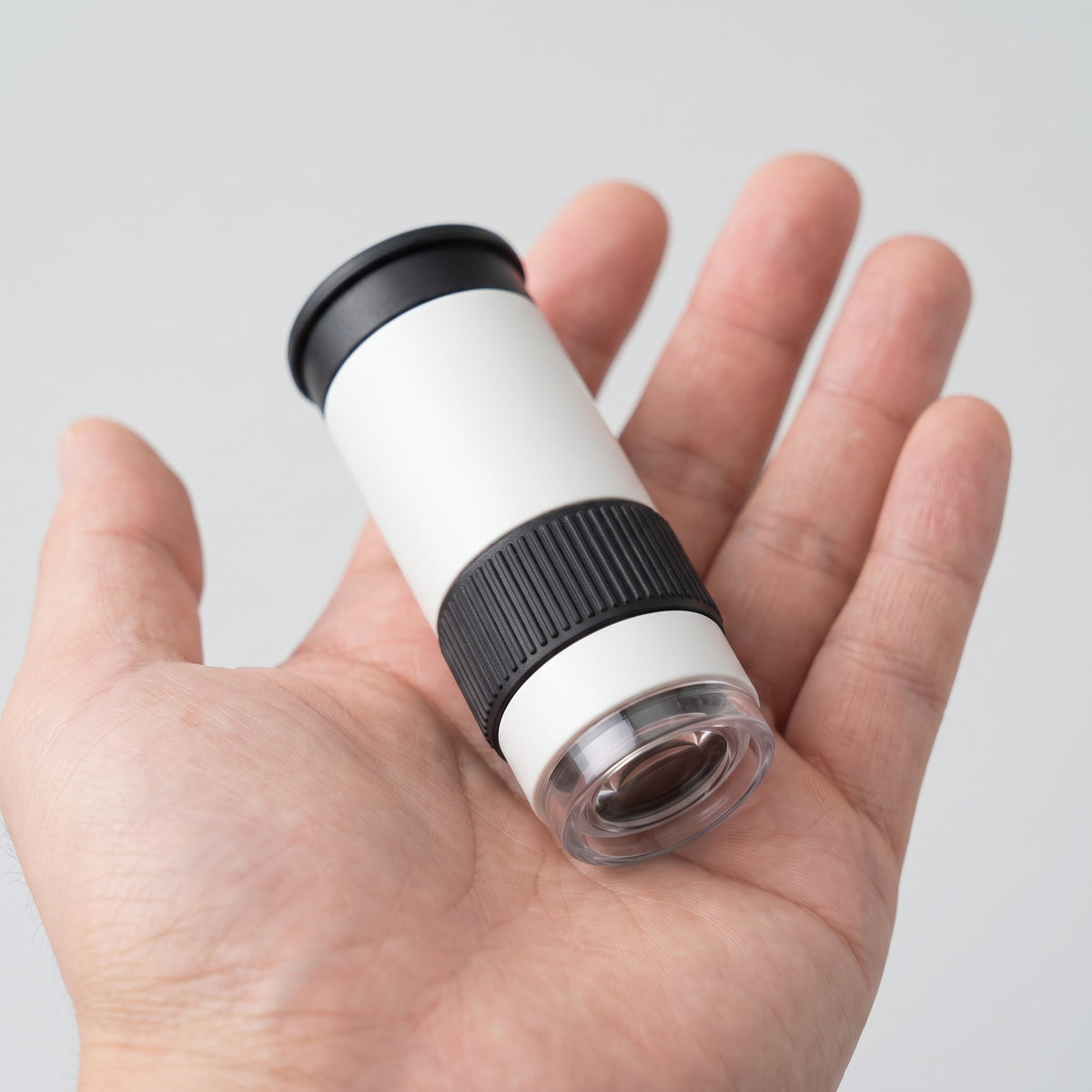 Curio Pocket Microscope held in an open palm to show its size